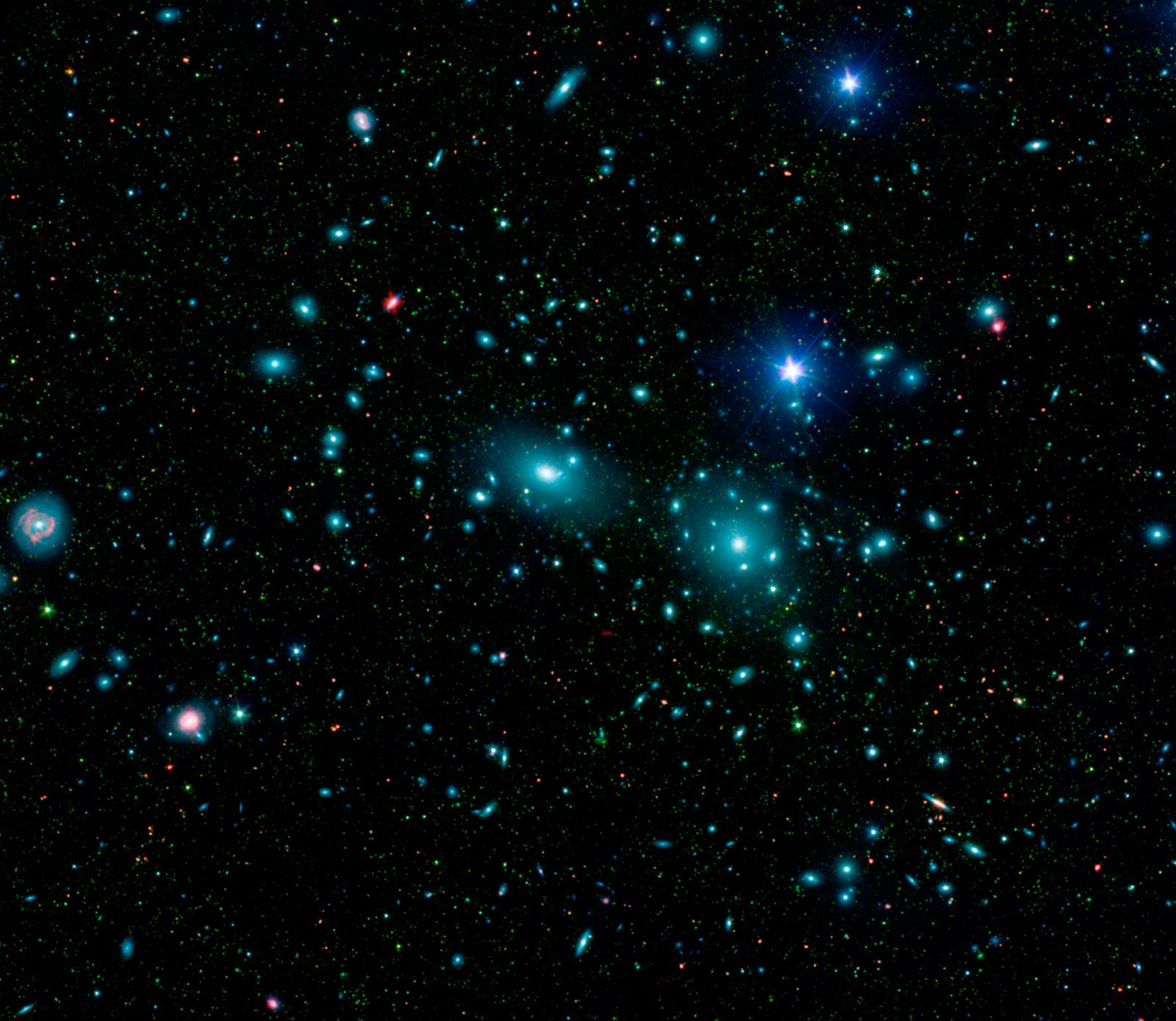 Toen Fritz Zwicky het Coma-cluster onderzocht, ontdekte hij dat er iets vreemds aan de hand was. Volgens zijn berekeningen op basis van de snelheden van de sterrenstelsels, moest de massa van dit cluster zo'n 400 keer groter zijn dan hij uit het licht van sterrenstelsels en gas kon afleiden. (Bron: NASA / JPL-Caltech / L. Jenkins (GSFC)) 