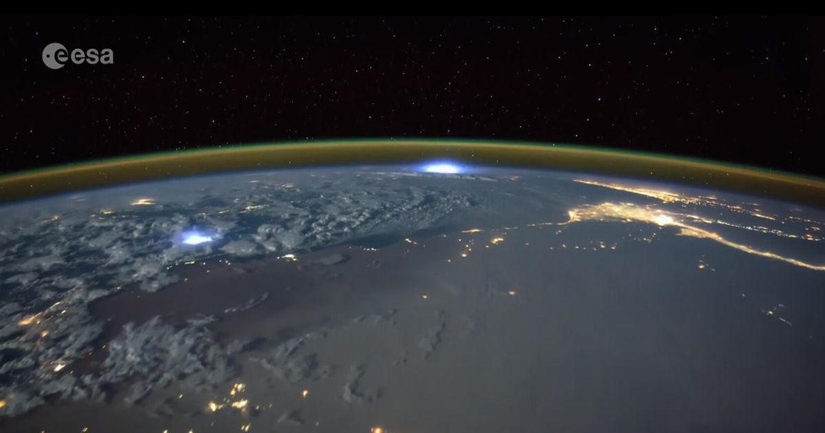 Een foto van de aarde, genomen van de ISS, waarin de atmosfeer en bliksem te zien is