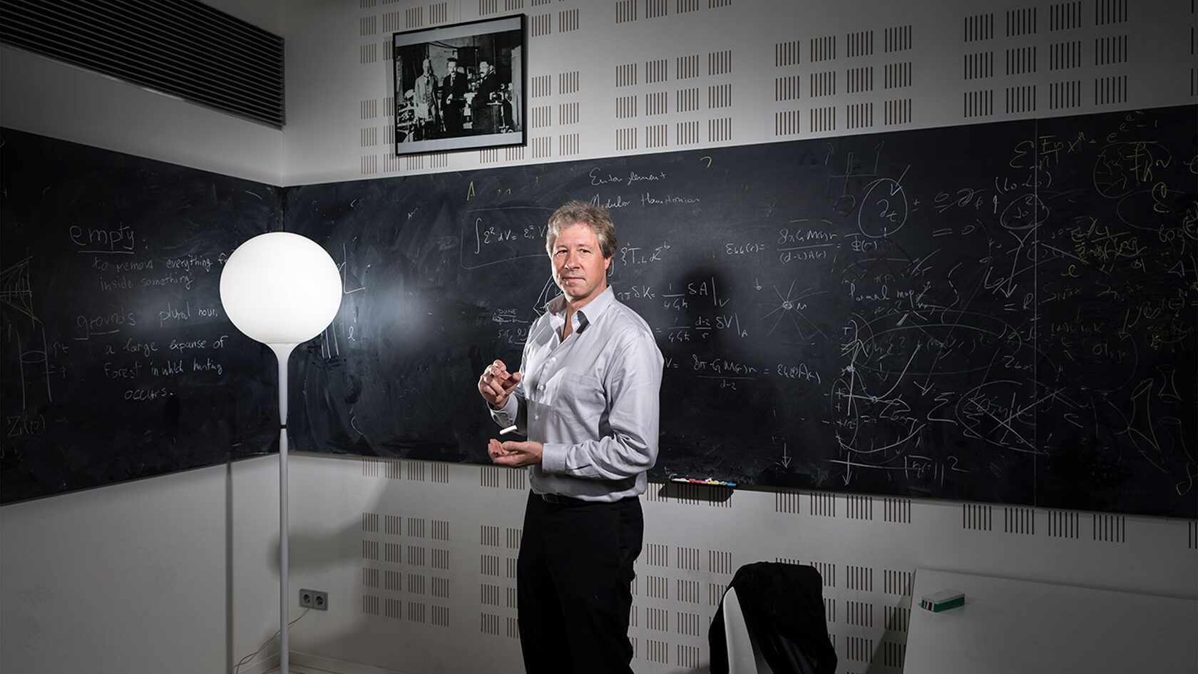 Foto van UvA-natuurkundige prof. Erik Verlinde, voor een krijtbord